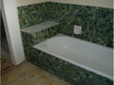 Bathroom with dark mosaic tiles before resurfacing