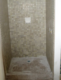 Grubby mosaic tiled shower recess before resurfacing