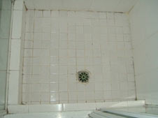 old floor tiles on shower floor with grout mould showing